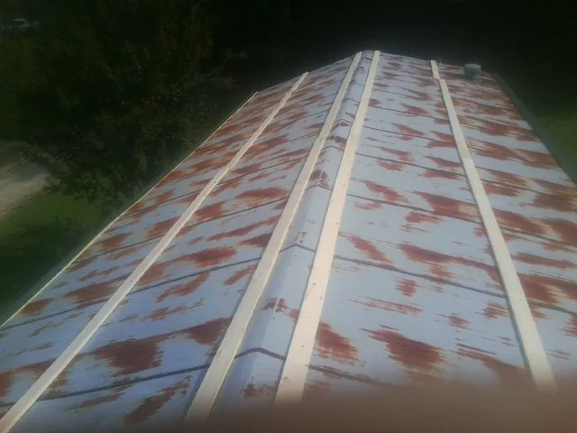 Rusted metal roof panels with new wood purlins before replacement — Storm Damage Roof Repair in Coffeen by Roofing Brothers