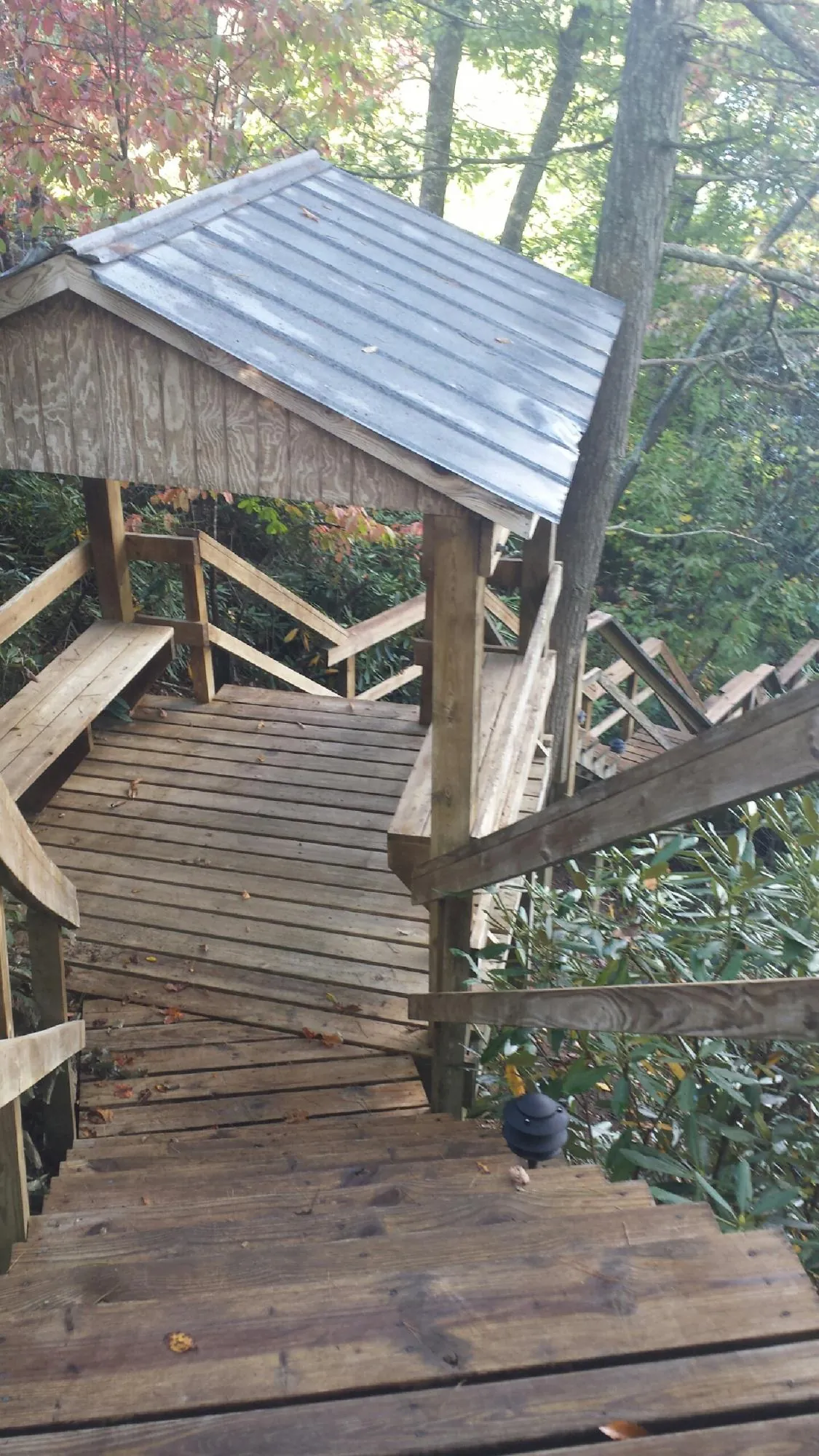 Metal roofed shelter over wooden steps on a wooded walkway — Skylight Repair & Installation work by our crew in Coffeen
